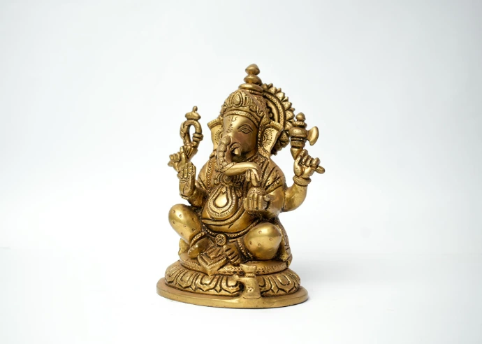 a gold statue of a person holding a staff